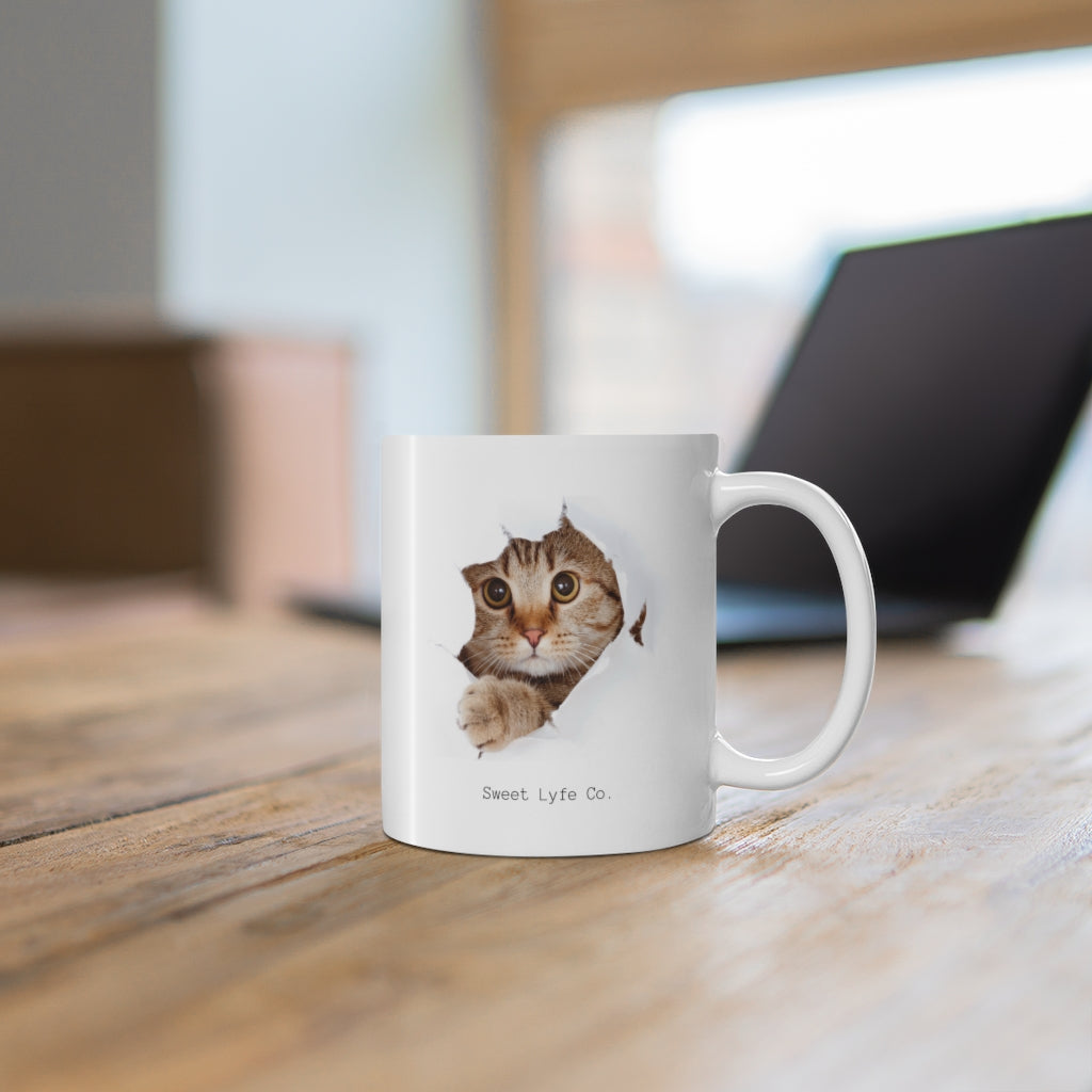 Calling all cat lovers! This cute cat mug has a cat peeking out. This mug is perfect for all cat moms and dads out there. This mug is 11 oz, lead and BPA free, and microwave and dishwasher safe!