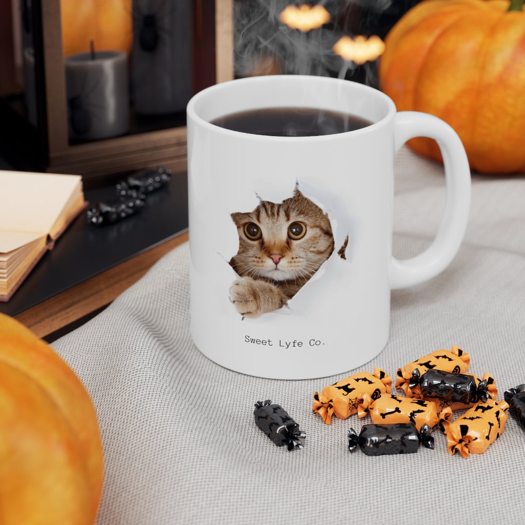 Calling all cat lovers! This cute cat mug has a cat peeking out. This mug is perfect for all cat moms and dads out there. This mug is 11 oz, lead and BPA free, and microwave and dishwasher safe! 